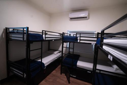 a room with three bunk beds and a fan at Slackpackr Hyderabad in Hyderabad