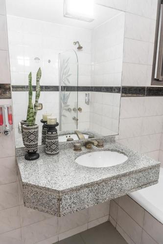 a bathroom counter with a sink and a mirror at Departamento Glamour 203 - Edificio VILAUT by INMOVE Temporarios in Córdoba