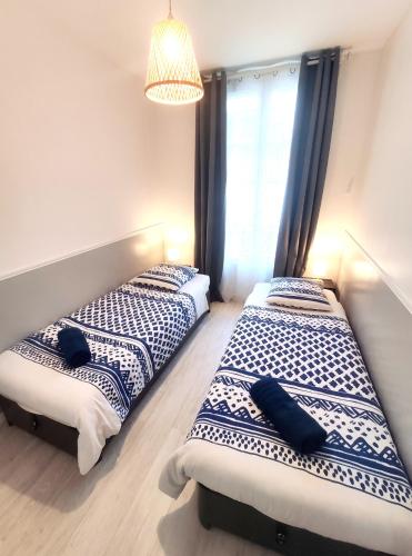 deux lits côte à côte dans une chambre dans l'établissement DisneyLand - Paris 20 min - Parking - 7 personnes, à Gournay-sur-Marne