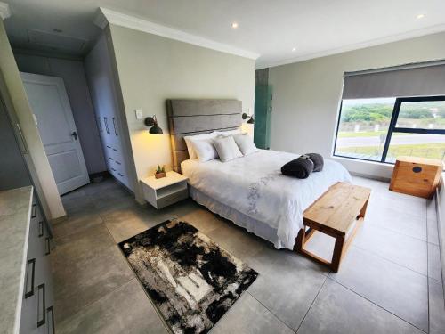 Un dormitorio con una cama y una ventana grande. en 59 Homestead Views, en St Francis Bay