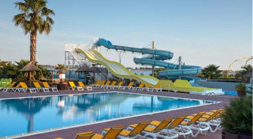 a swimming pool with a water slide at a resort at Mobil home IRM Excellence dans parc Natura 2000 Lac des rêves piscine ect sous fun pass in Lattes