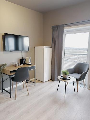 a living room with a desk and a refrigerator at E18rom Motell in Tønsberg