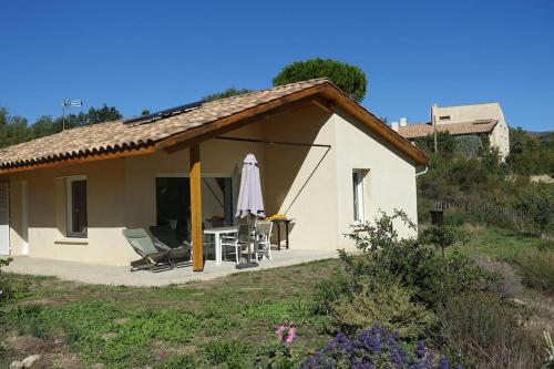 a small house with a table and a umbrella at Gîte Provence Pure Nature in Digne-les-Bains