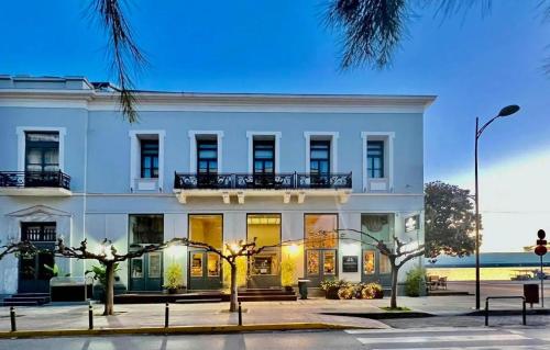 an exterior view of a white building with a balcony at Panellinion Luxury Rooms in Kalamata