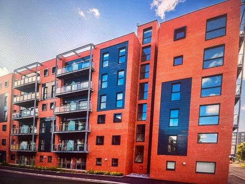 a red brick building with balconies on a street at Cosy City Apartment in Manchester in Manchester