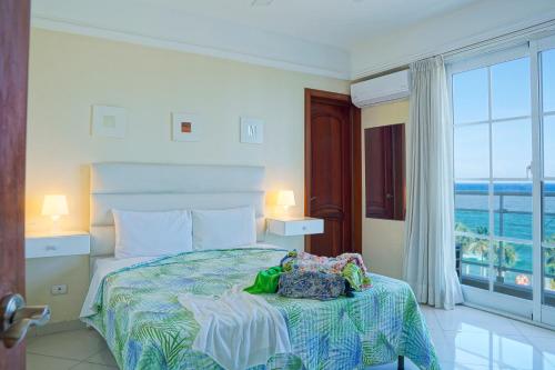 a bedroom with a bed with a view of the ocean at Hotel Shakey in Santo Domingo