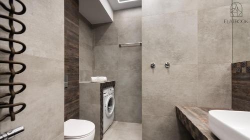 a bathroom with a toilet and a washing machine at Flatbook - City Center SPA Apartments 6B,C in Gdańsk