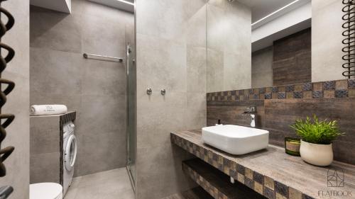 a bathroom with a sink and a shower at Flatbook - City Center SPA Apartments 6B,C in Gdańsk