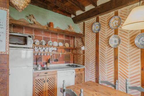 a kitchen with a white refrigerator and a table at Capellan in Olmos de Ojeda