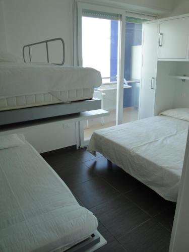 a bedroom with two beds and a window at Residence La Nave in Senigallia