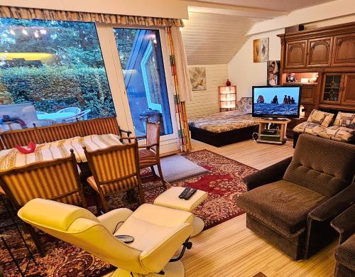 a living room with a couch and a tv in a room at Winterberg Appartement 6 Pers am Skilift größten Skigebiets, ruhige Garten im Wald, gemütlichen Après-Ski-Cafés Restaurants zu Fuß erreichbar, Parkplatz, Schwimmbad, Sauna, Relaxraum, Buchbaren Massages Wellness Der Brabander, Darts Tischtennis-Fußball in Winterberg