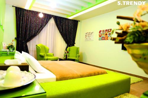 a bedroom with a green bed and green chairs at Layali Al Shams Hotel in ‘Anjar