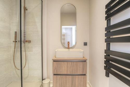 une salle de bain avec un lavabo et un miroir dans l'établissement Joli appartement T2, bien équipé, Saint-Didier, à Saint-Didier-au-Mont-dʼOr