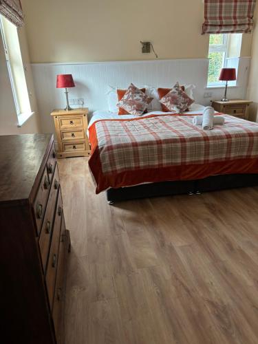 a bedroom with a bed and a wooden floor at An Caislean incorporating Corratavey in Ballycastle