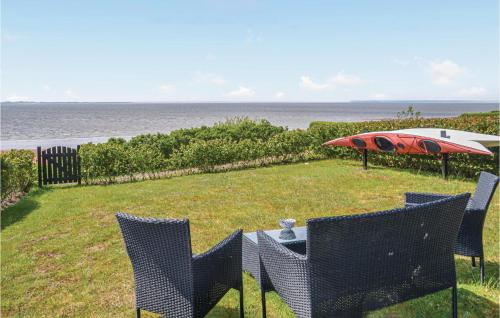 エスビャウにあるFour-Bedroom Holiday Home In Esbjerg Vの椅子とパラソルが並ぶテーブル