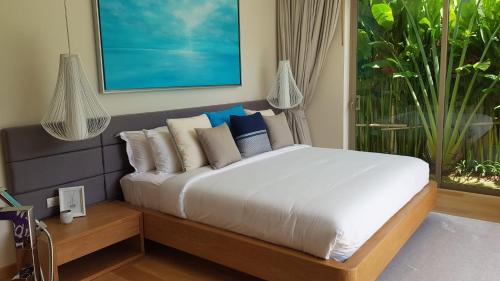 une chambre avec un lit avec des oreillers et une fenêtre dans l'établissement Luxury 3 bedroom pool villa, à Laguna Phuket