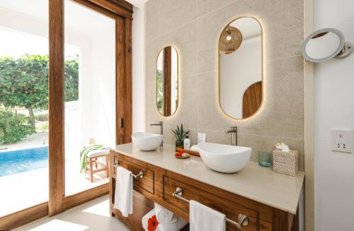a bathroom with two sinks and a large window at Kisiwa on the Beach in Paje