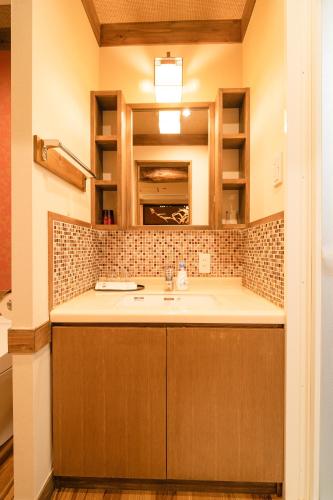 a bathroom with a sink and a mirror at 都電屋 TodenHotel in Tokyo