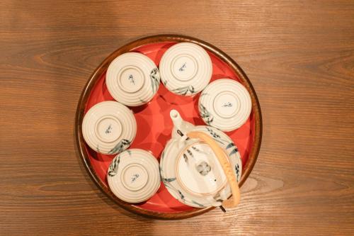 a bowl filled with white dishes on a wooden table at 都電屋 TodenHotel in Tokyo