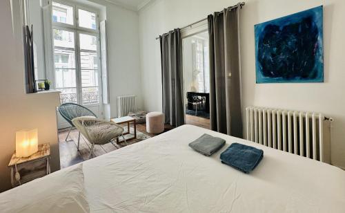 une chambre avec un lit blanc avec deux oreillers dessus dans l'établissement Rolland, à Bordeaux