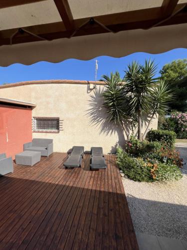a deck with two lounge chairs and a palm tree at Camping Del Mar 260, Mobile Home Excellence, 3 chambres, 6 personnes, bord de mer in Argelès-sur-Mer