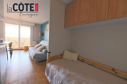 une chambre avec un lit et un canapé dans une pièce dans l'établissement Le Madura, à Sausset-les-Pins