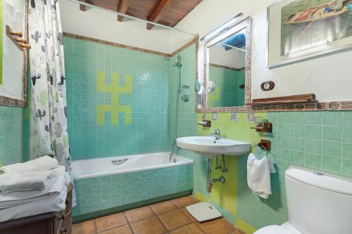 a bathroom with a sink and a tub and a toilet at La Escuela de la Sorrueda by Villas Rivero in La Sorrueda