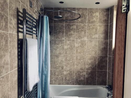 a bathroom with a tub and a shower curtain at Bassett Home - Double Room And Free Parking in Southampton