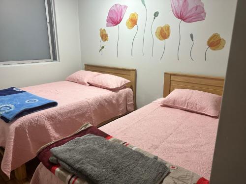 SMiguel, 1P Grande dpto, 4 camas, wifi, lavadora terraza في ليما: سريرين في غرفة بها زهور على الحائط