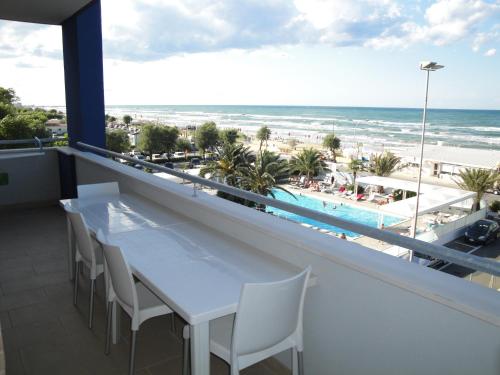 a balcony with a table and chairs and the beach at Residence La Nave in Senigallia