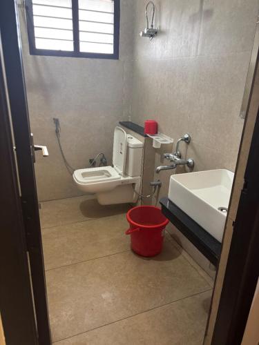 a bathroom with a toilet and a sink and a bucket at Golden Residency in Nāgappattinam