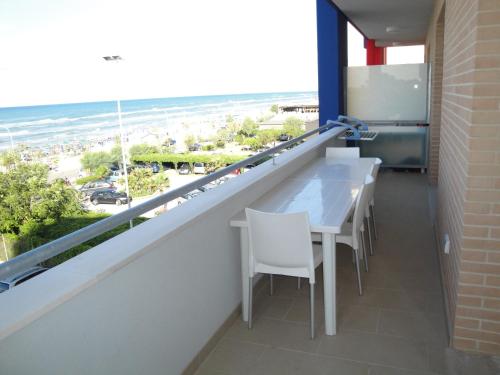 a balcony with a table and chairs and the beach at Residence La Nave in Senigallia