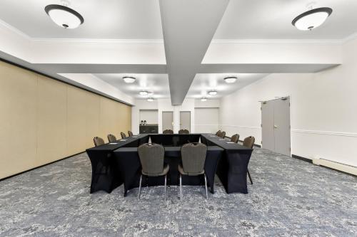 a conference room with a black table and chairs at Clarion Suites Anchorage Downtown in Anchorage