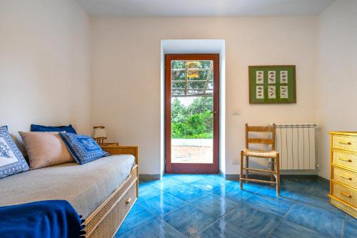 a bedroom with a bed and a chair and a door at Dimora Punta Rossa in San Felice Circeo