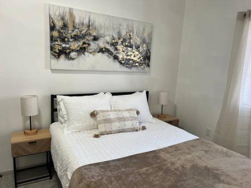 a bedroom with a bed with two nightstands and a painting at Affordable Stay Near Proctors A2 in Schenectady
