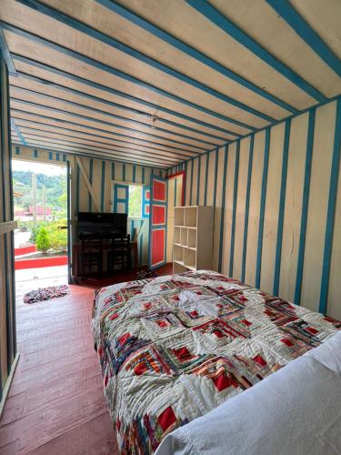 a bedroom with a bed in a room with a piano at El Agrado Restaurante Cabañas in Líbano