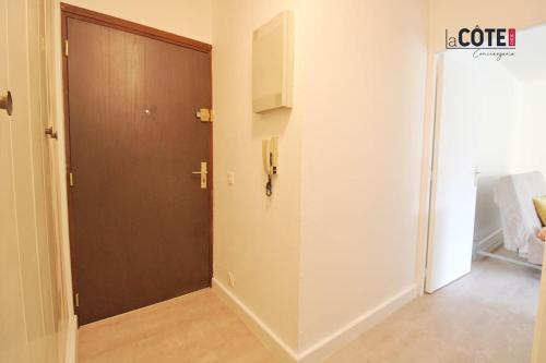 un couloir avec une porte marron et une chambre dans l'établissement Le Corvette 3, à Carry-le-Rouet
