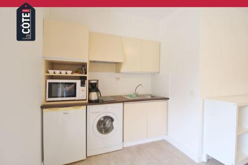 une cuisine avec un lave-linge et un micro-ondes dans l'établissement Le Corvette 3, à Carry-le-Rouet