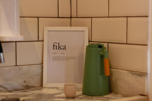 a green thermos next to a picture and a sign at Villa Estrela Bungalow in Itacaré