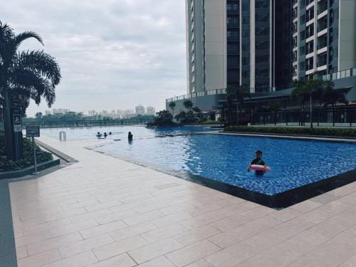 a person in a paddle board in a swimming pool at TheBess Hotel Tokyo is located adjacent to Singapore and offers a sea viewIt is a family business smart room with the sea view of Princess Bay富力公主湾 in Johor Bahru