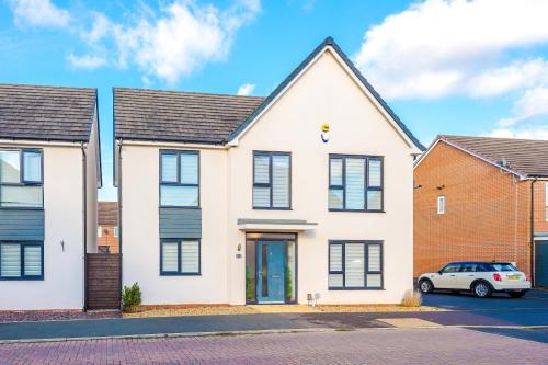 a white house with a car parked in a parking lot at Hasting's House by YourStays - 3 Bedroom House in Stoke-on-Trent in Stoke on Trent