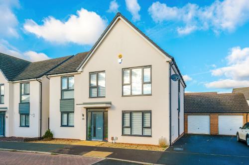 a white house with a garage at Hasting's House by YourStays - 3 Bedroom House in Stoke-on-Trent in Stoke on Trent