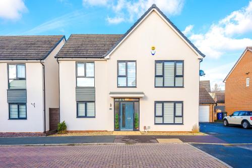 a white house with black windows at Hasting's House by YourStays - 3 Bedroom House in Stoke-on-Trent in Stoke on Trent