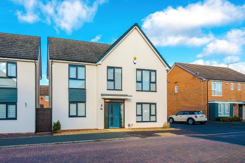 a white house with a car parked in a parking lot at Hasting's House by YourStays - 3 Bedroom House in Stoke-on-Trent in Stoke on Trent