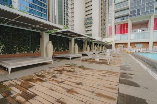 a patio with benches and a pool in a building at Yoo Panamá by Boutique Apartments in Panama City