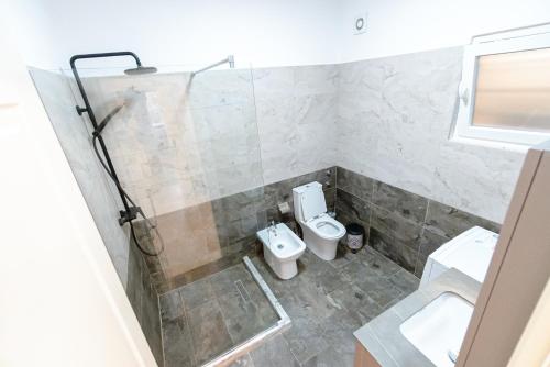 a bathroom with a toilet and a sink at Kotarja Apartments in Dhërmi