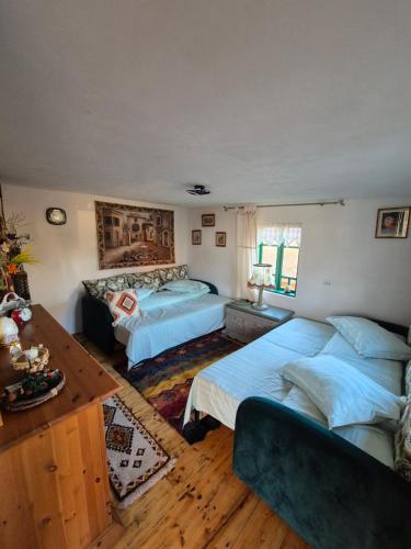 a bedroom with two beds and a table and a couch at Căsuță Baciului in Berevoeşti