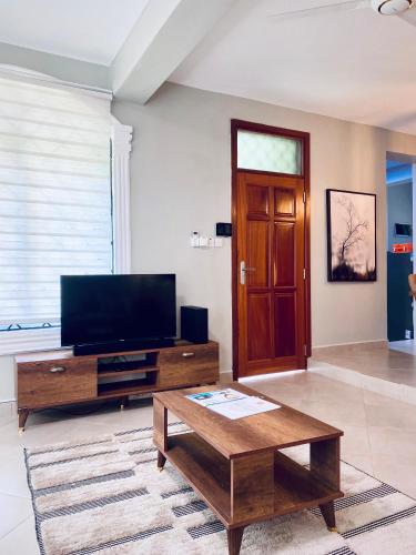 a living room with a television and a coffee table at Jacomo Residences in Dar es Salaam