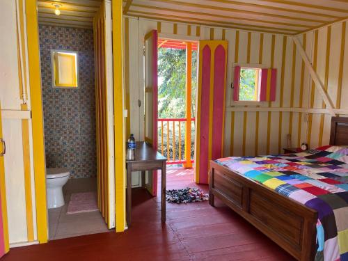 a bedroom with a bed and a bathroom at El Agrado Restaurante Cabañas in Líbano