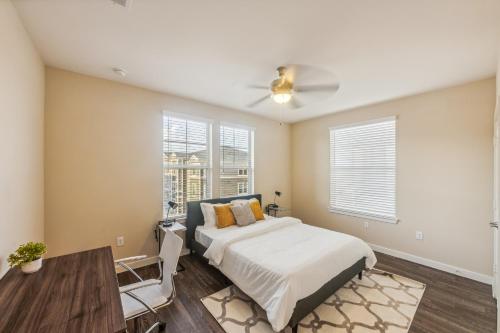 a bedroom with a bed and a table and some windows at Cullen 4307 I Parking I Pool I Gym I 2bd2bth in Houston
